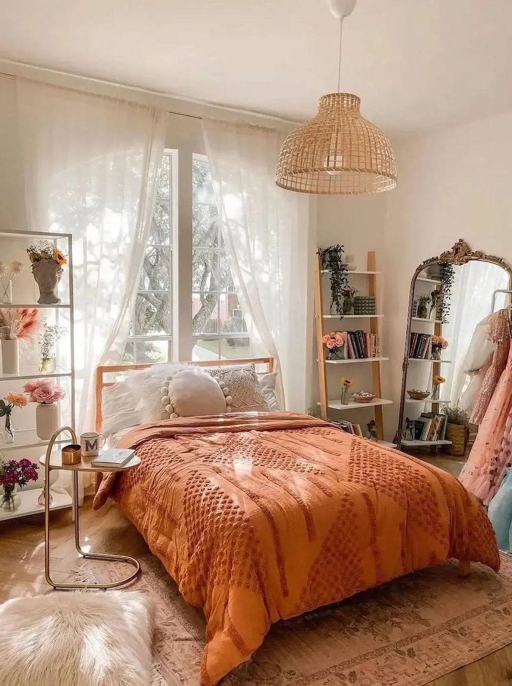 a feminine boho bedroom with pink and orange tones, florals, faux fur accents, and a statement raffia lighting fixture
