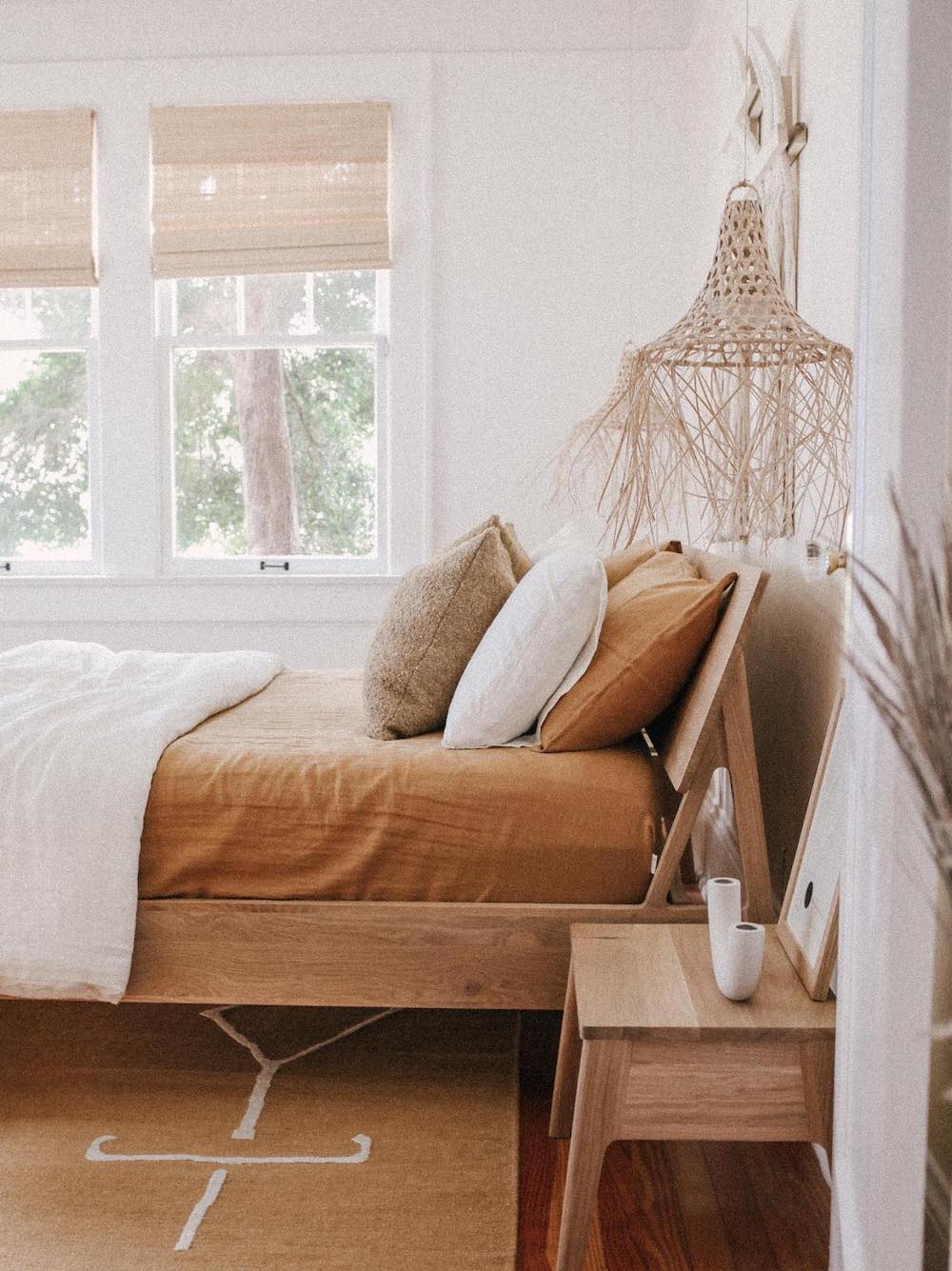 a warm-toned boho bedroom with natural wood and decor