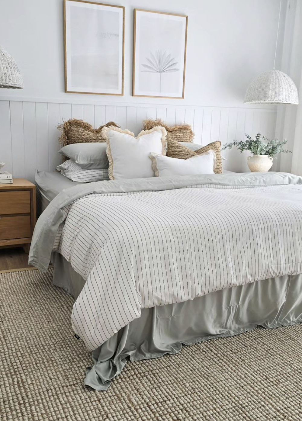 a coastal-inspired boho bedroom with raffia accents, ivory and sage tones, and natural wood details