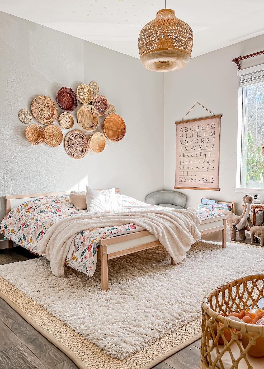 a children's bohemian bedroom with floral bedding, wall basket decor, and natural rattan accents