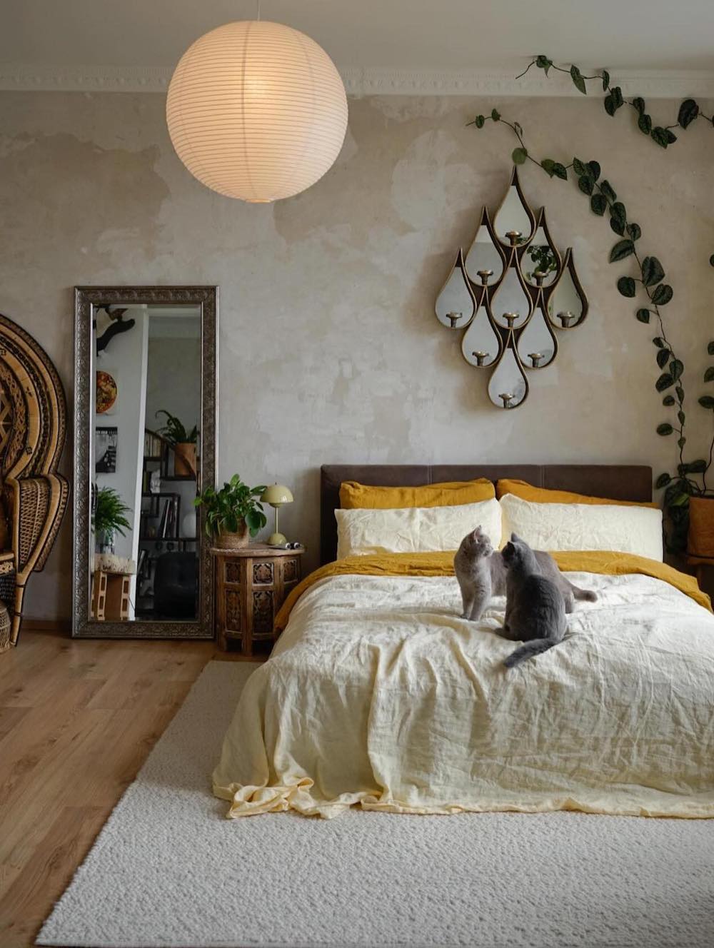 an elevated bohemian bedroom with a rattan peacock chair, limewashed walls, and muted earthy colors