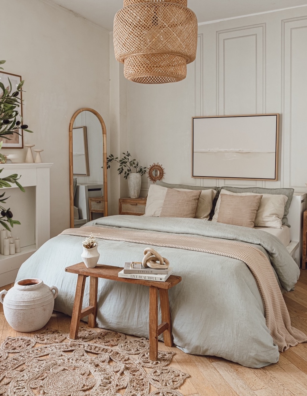 a bohemian-inspired bedroom featuring soft tones minimalist art, raffia and jute accent pieces, and an elevated decor style