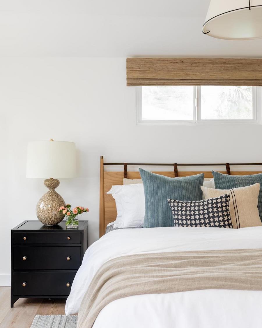 a coastal themed bedroom with black, beige, blue, and peach tones