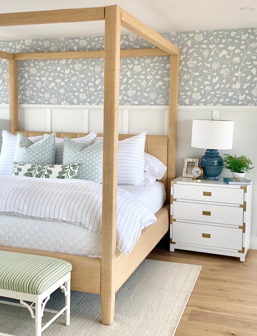 a beachy bedroom featuring floral wall print, soft blue tones and pops of green