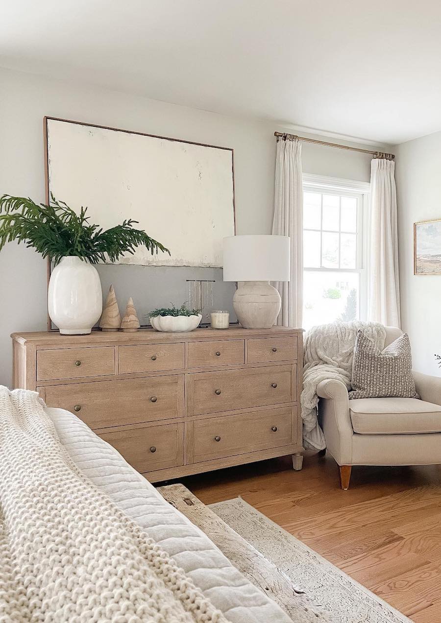 a neutral coastal bedroom with natural wood and cozy knits