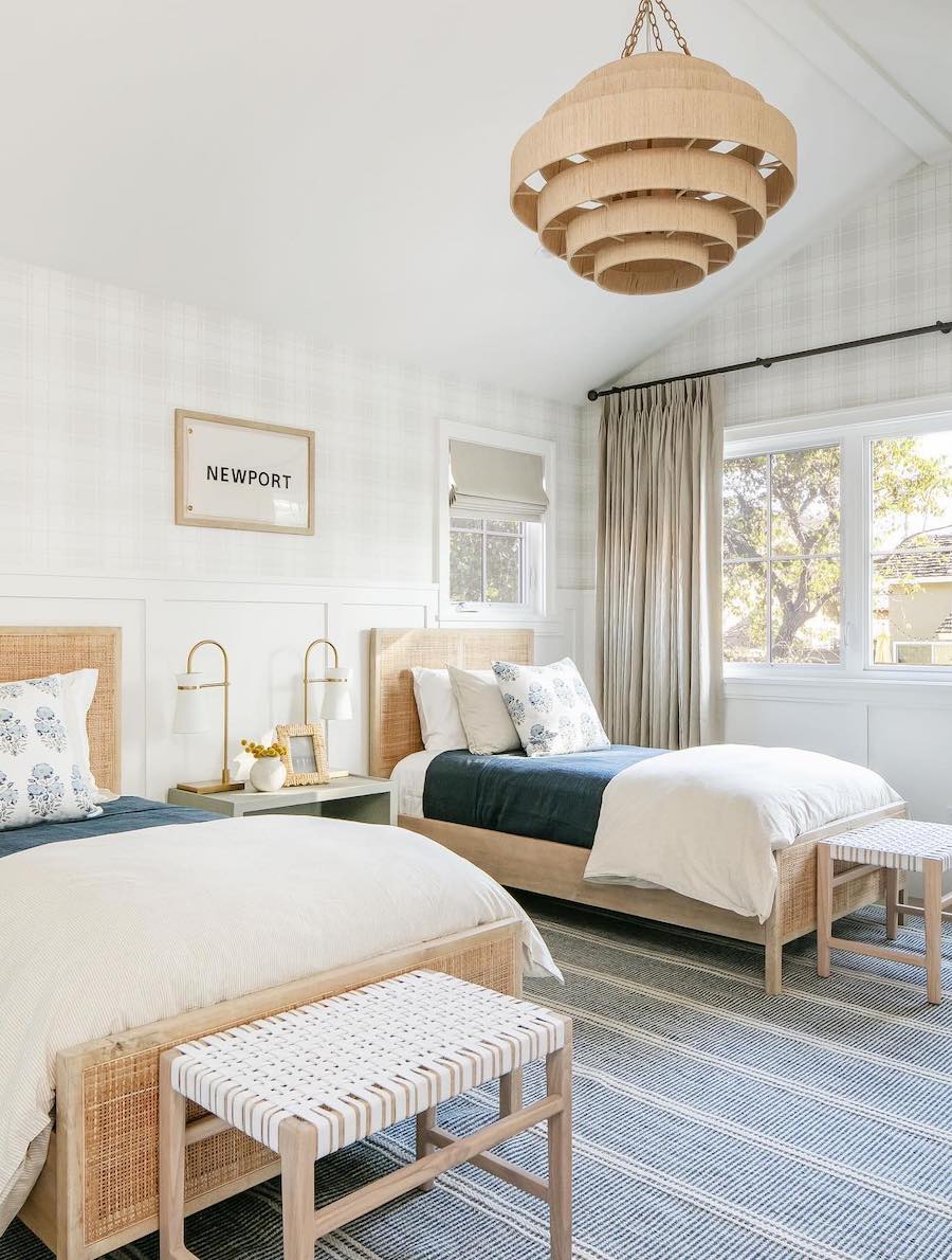 a beachy bedroom with two beds, featuring sandy beige, navy, and white colors