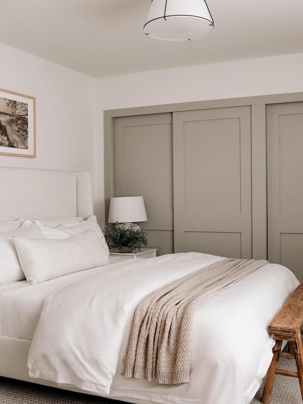 a bedroom with taupe and ivory walls and crisp white bedding