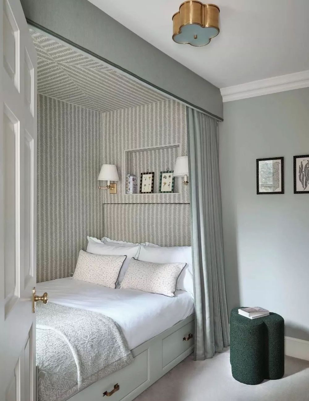 a bedroom with striped wallpaper, blue wall paint, and traditional decor