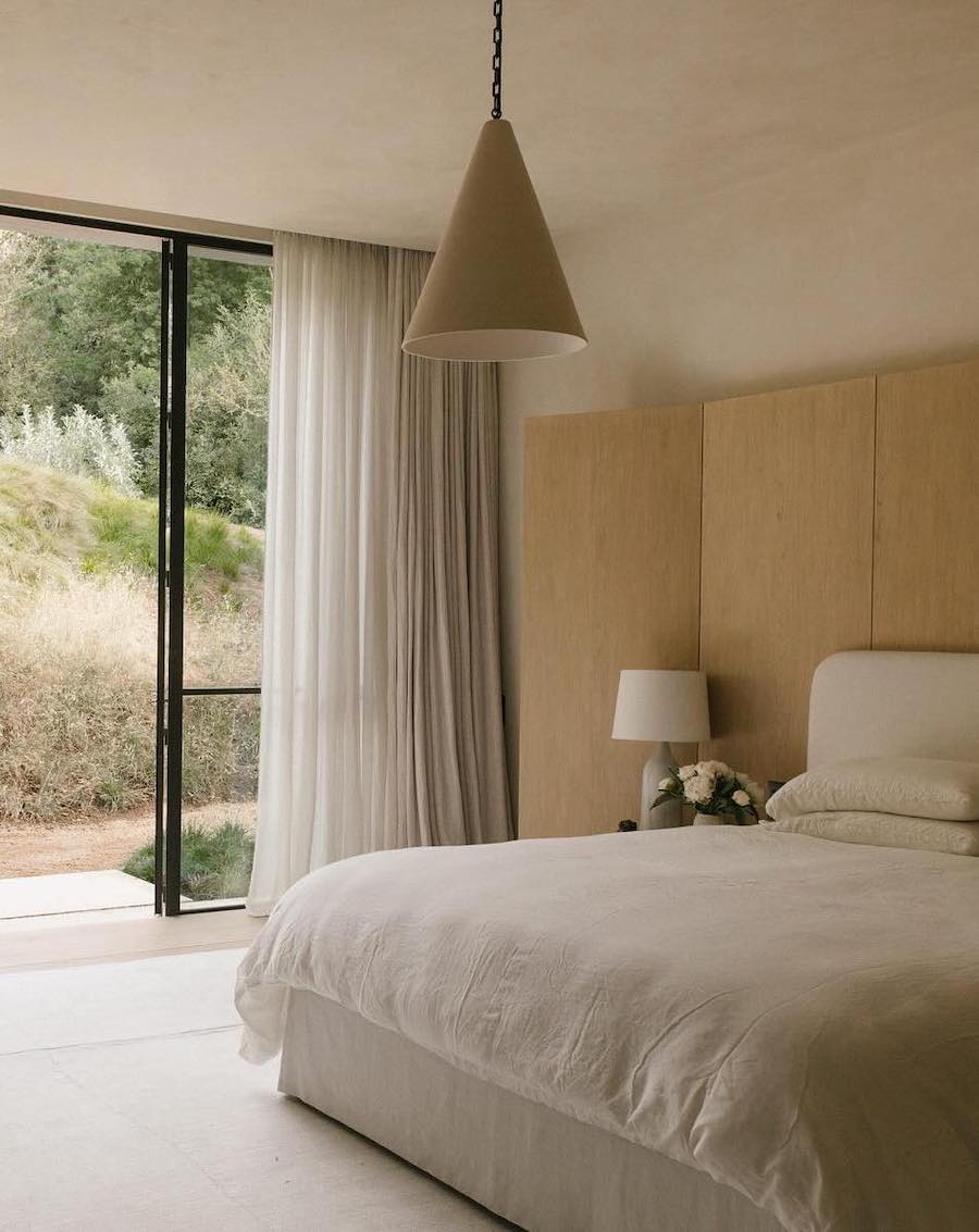a bedroom featuring a organic modern design with subdued lighting, ecru tones, and simple decor