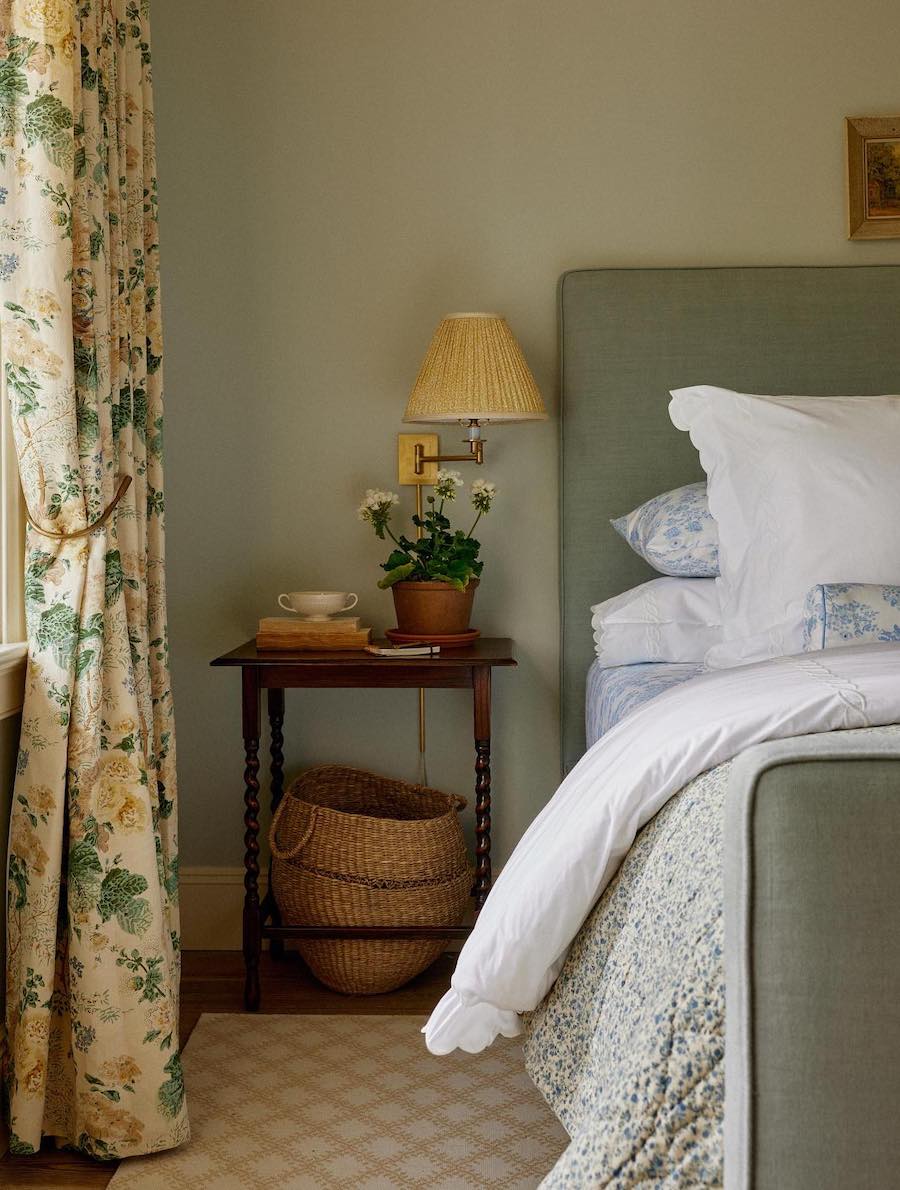 a cottagecore bedroom with sage green walls and floral decor