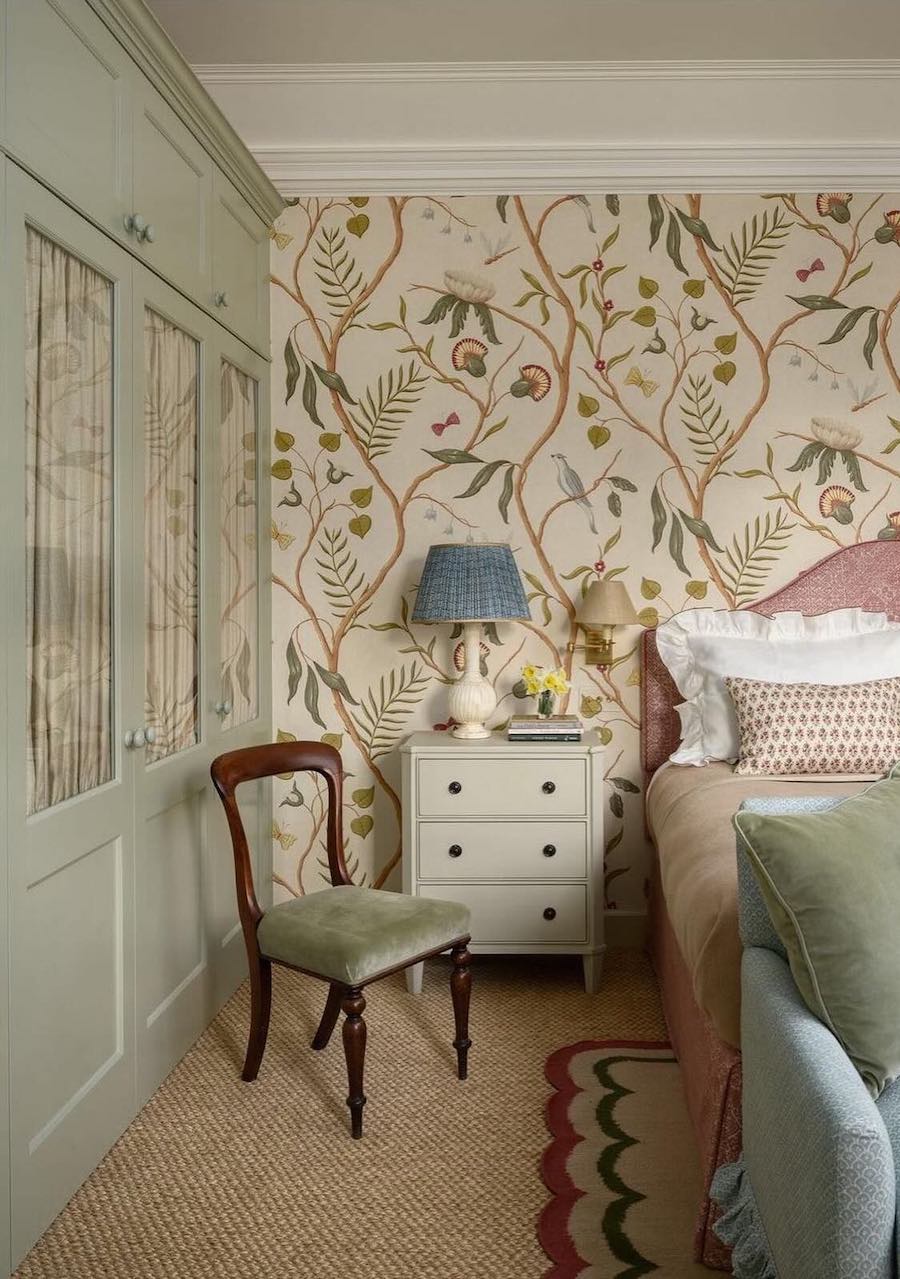a vintage, floral bedroom with sage green wall paint, furniture, and pillows