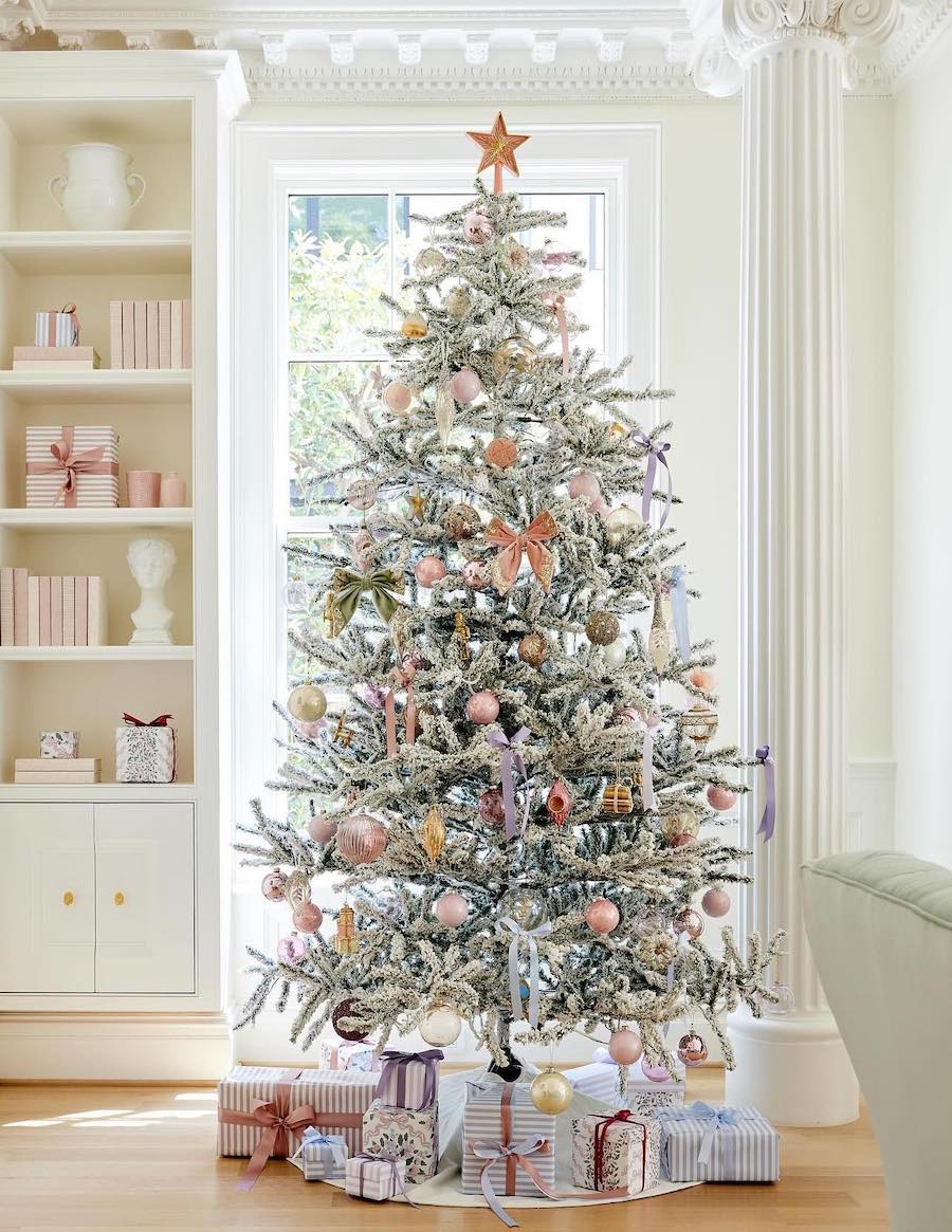 a snowy christmas tree with pink and gold decorations