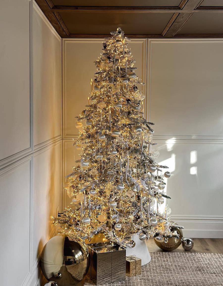 a snowy silver christmas tree with faux candles and ornaments