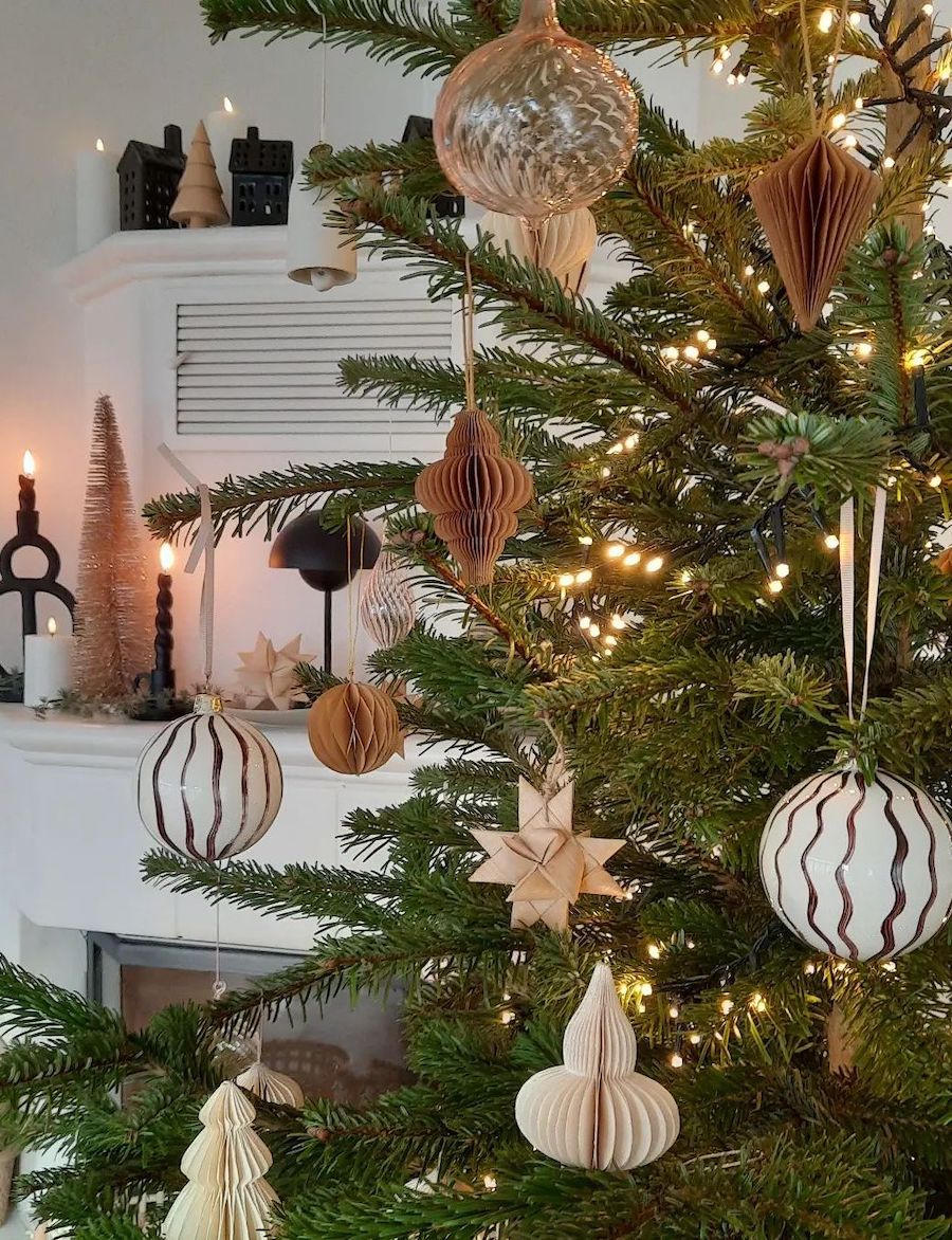 an up-close shot of a Christmas tree featuring classic ornaments in neutral tones