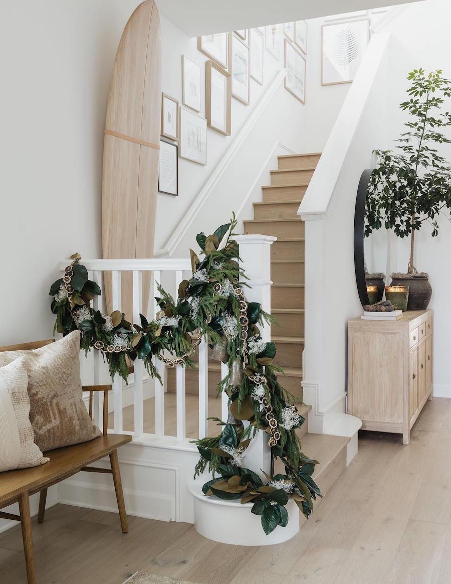 a staircase with pine and eucalyptus garland and dried orange slices