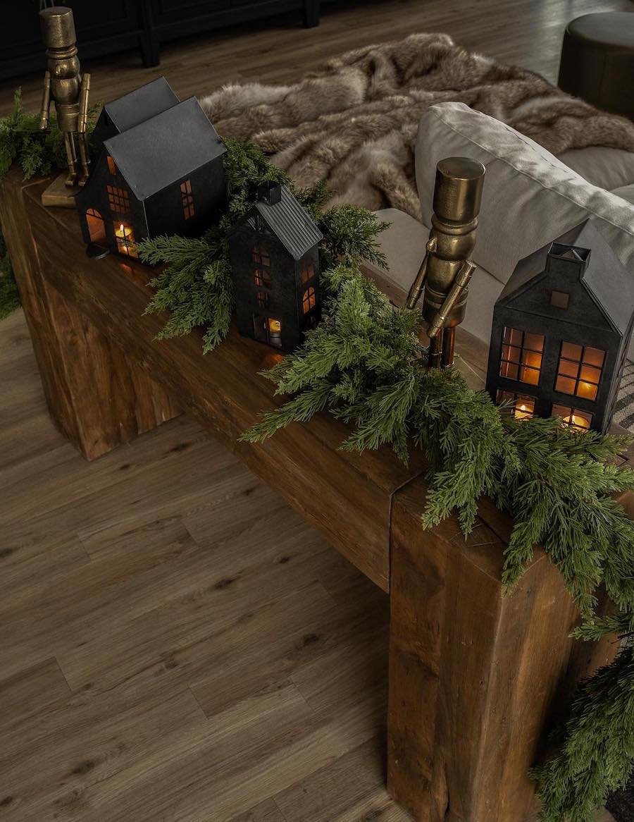 a side table with black village houses, pine, and golden nutcrackers