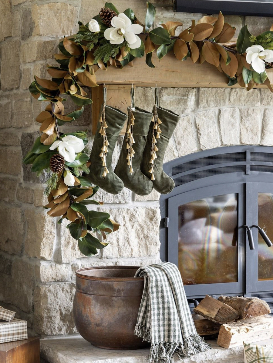 a fireplace with christmas garland and stockings