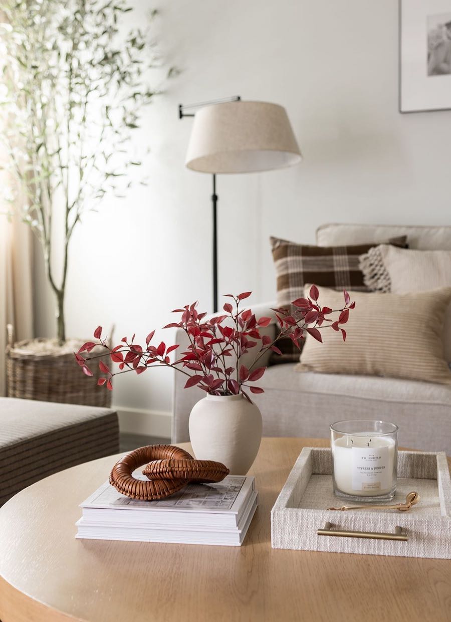 red fall foliage, brown plaid pillows, and other warm fall decor in a bright living room