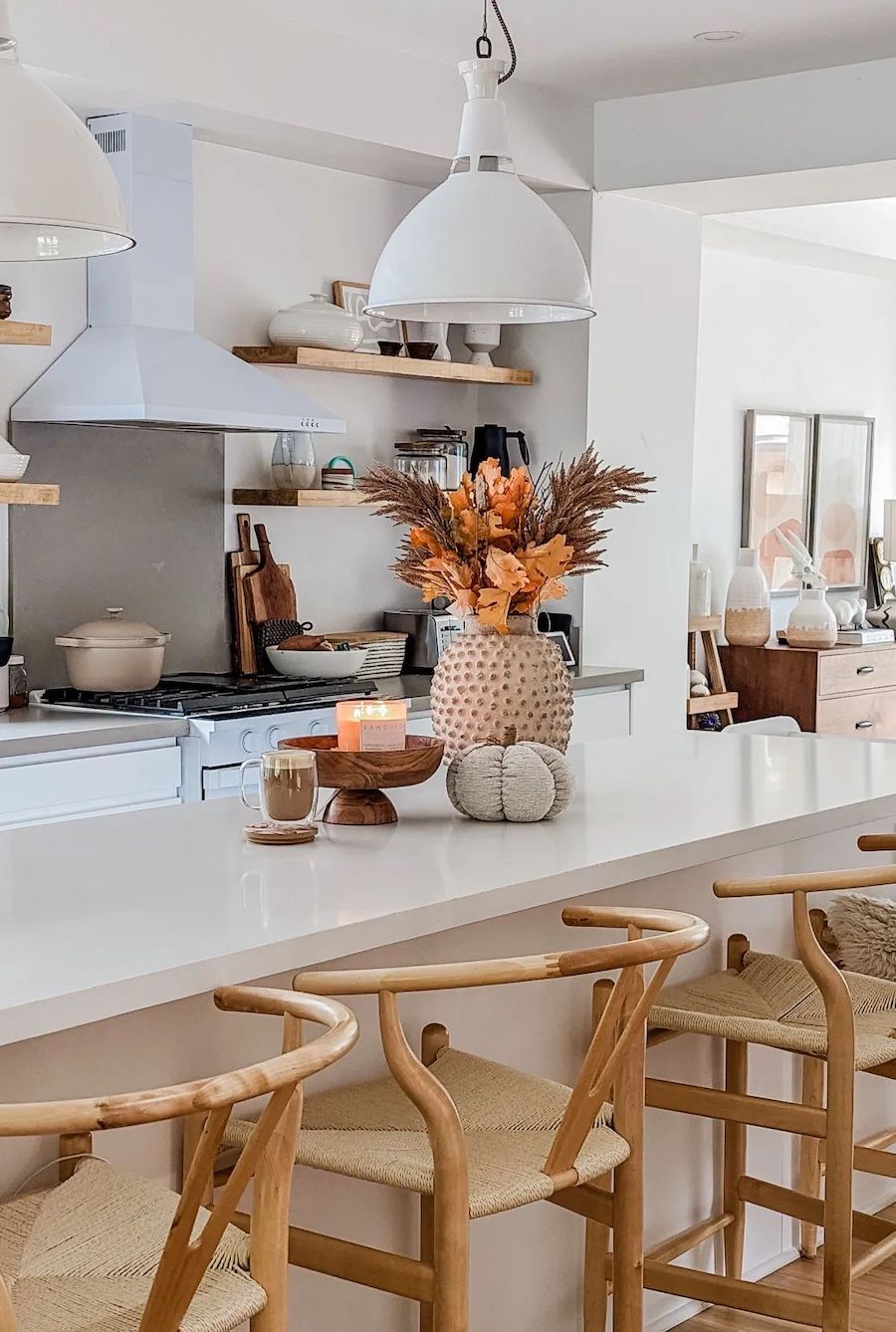 a white kitchen with a fall bouquet, pumpkin accents, and farmhouse decor