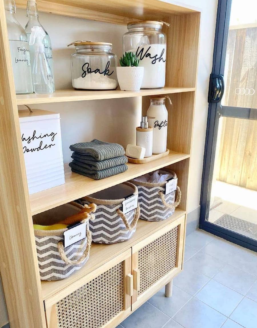 a hutch with open shelving and cabinets being used for laundry room organization