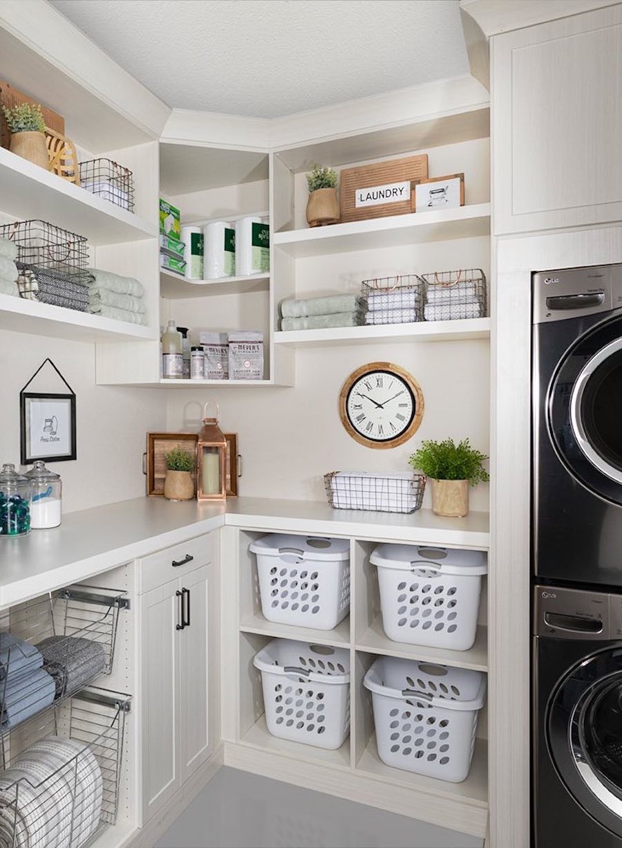 a laundry room with pull out baskets, wire baskets, cabinets, and open shelving