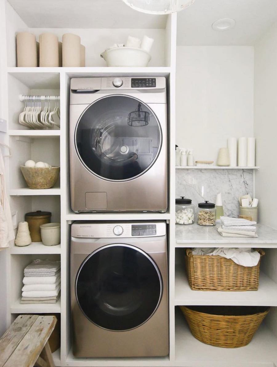 a laundry room with shelving on both sides of the machines