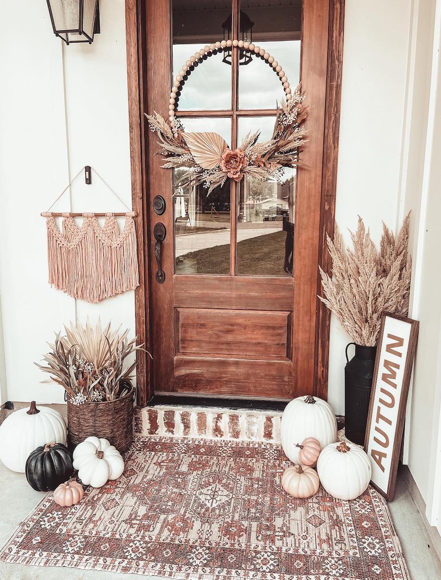 a front porch with bohemian flair, pumpkins, and fall florals