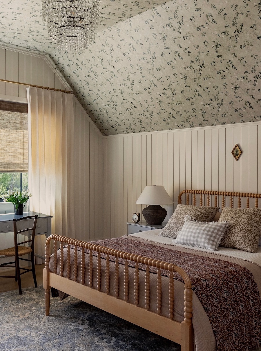 a vintage-inspired room with sage green floral wallpaper and cream-colored shiplap