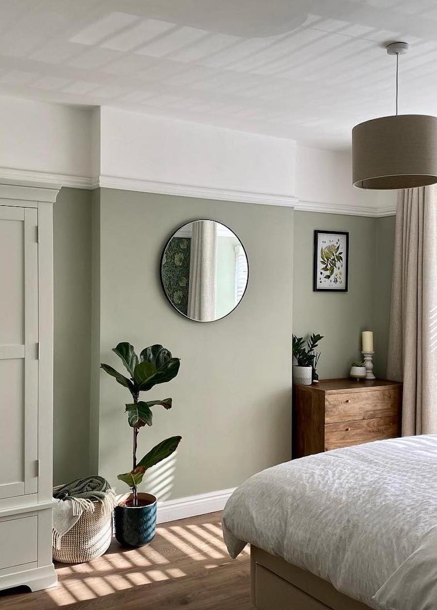 a minimalist boho bedroom with sage green wall paint