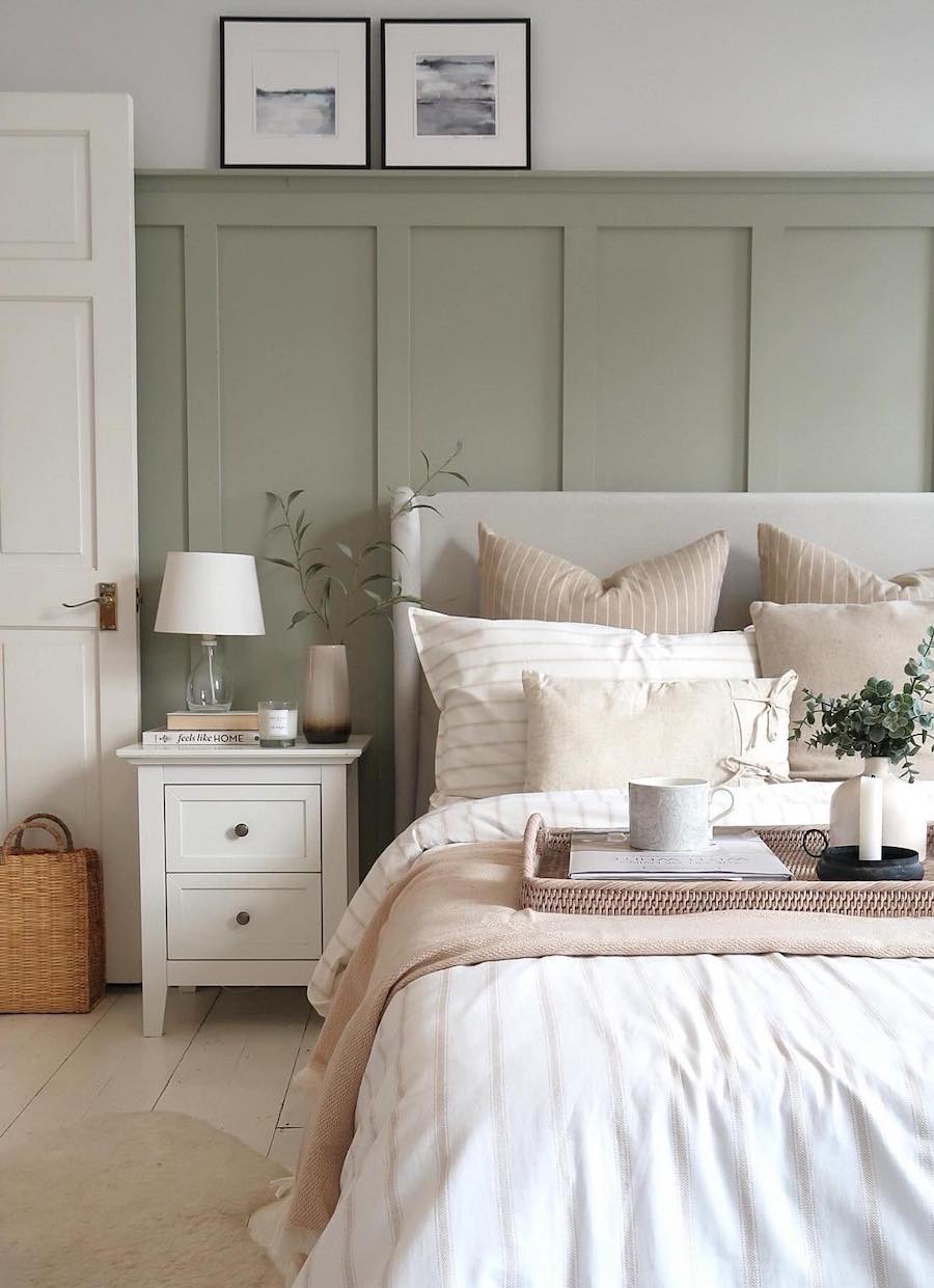 a bright and modern bedroom with a sage green accent wall