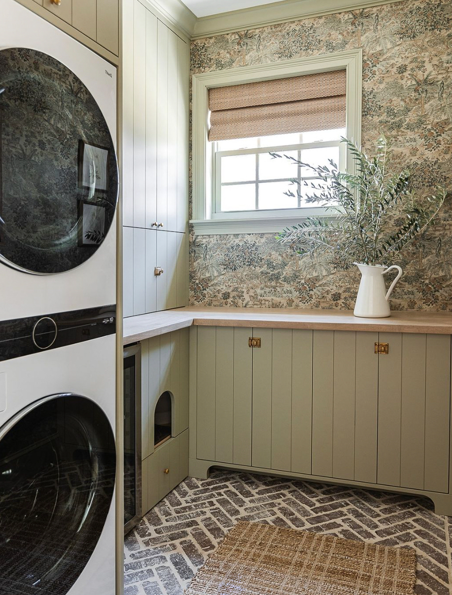 a cottage style laundry room with stone floors and floral wallpaper