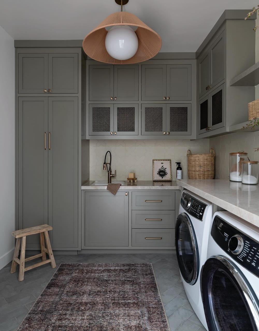 a cottage style laundry room muted green paint and neutral decor