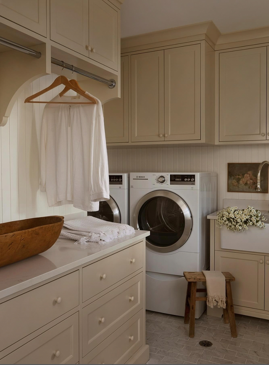 a cottage style laundry room with soft muted tones and natural decor