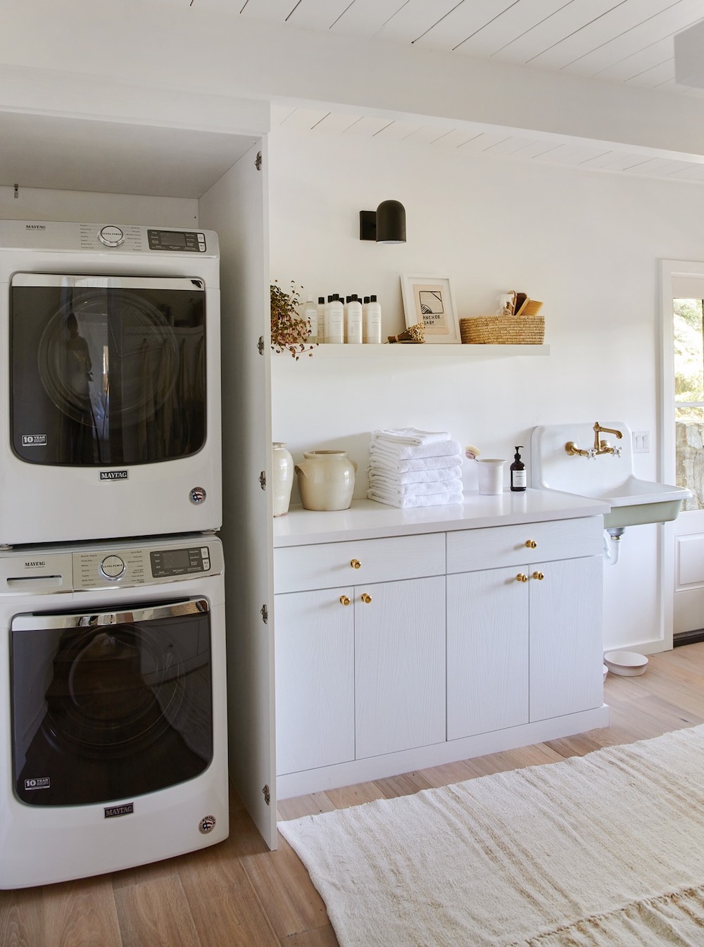 a cottage style laundry room with white and black decor