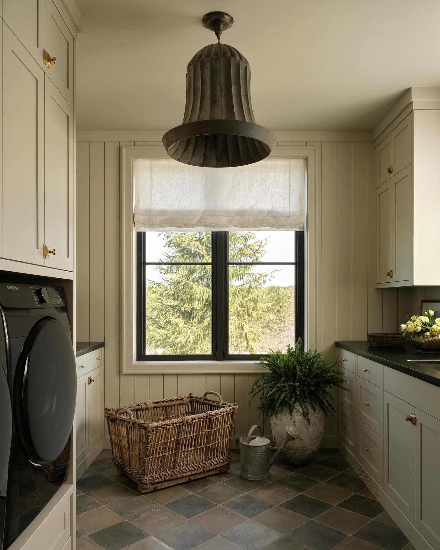 a neutral cottage style laundry room with pops of black