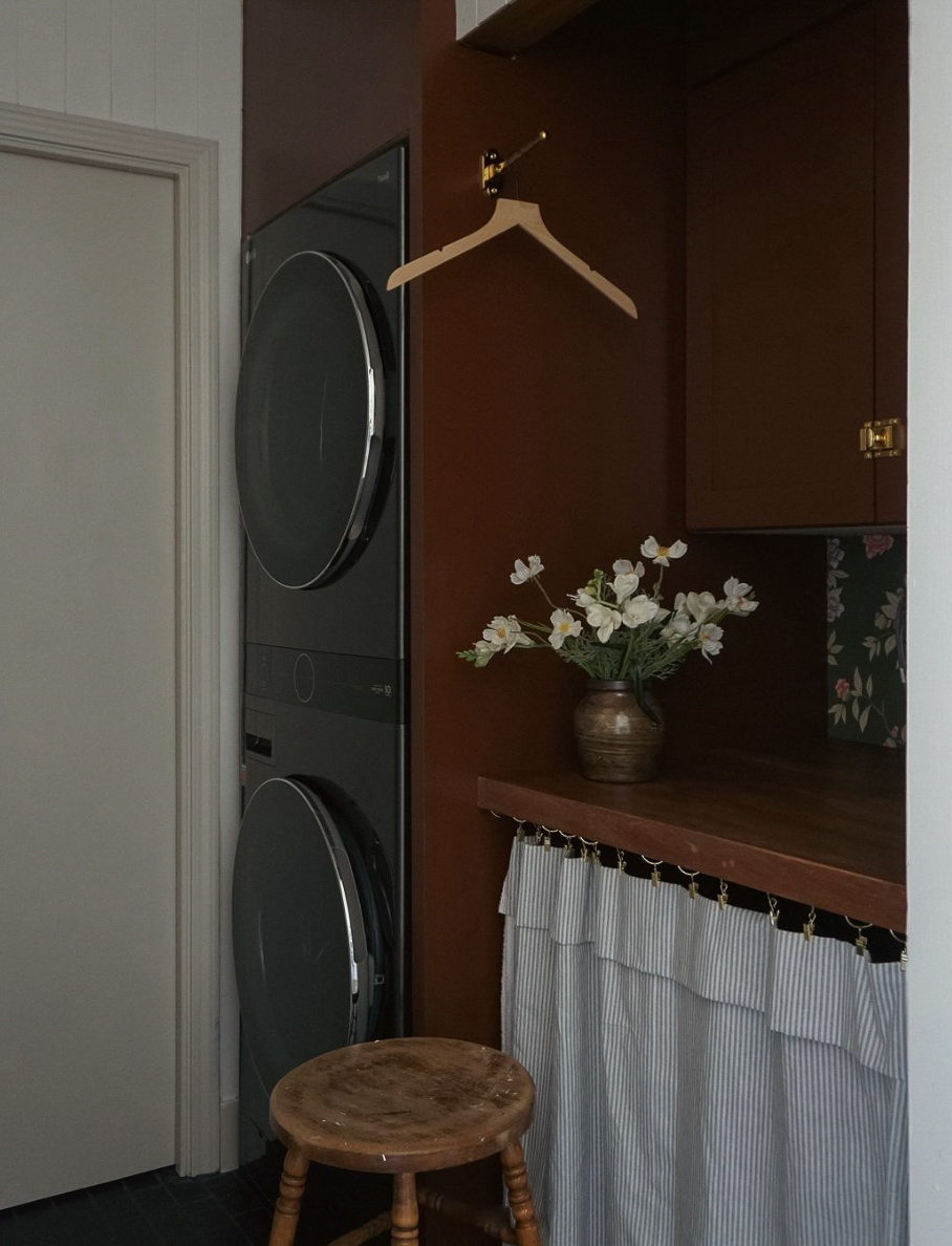 a cottage style laundry room with moody decor