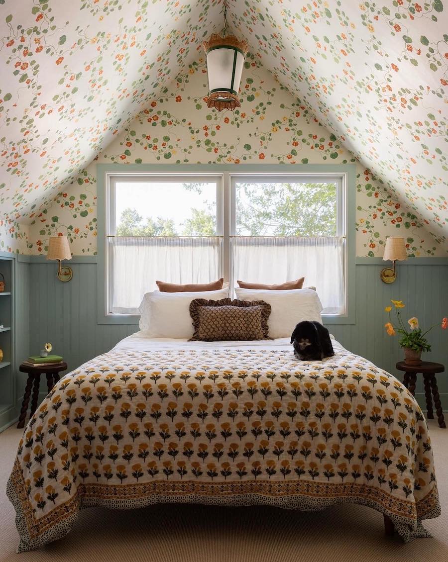 a cottagecore bedroom with floral wallpaper, blue shiplap, and vintage decor