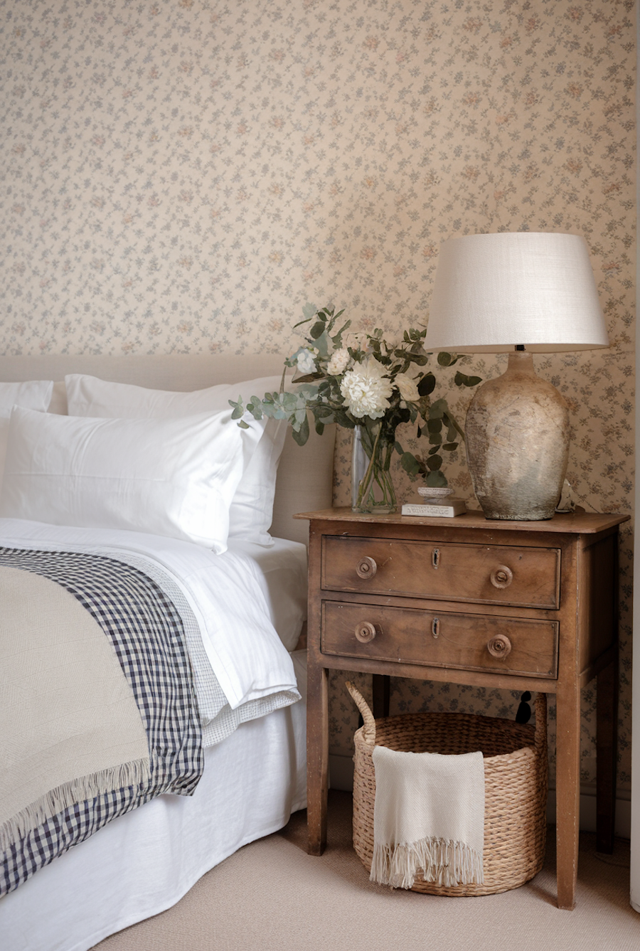 a cottagecore bedroom with floral wallpaper and vintage furnishings