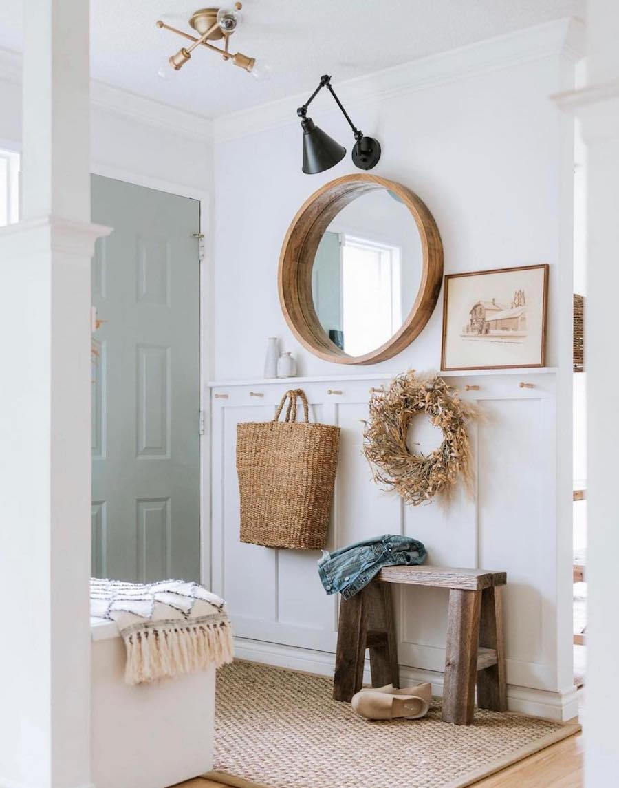 an entryway with white and sage paint with warm boho accents