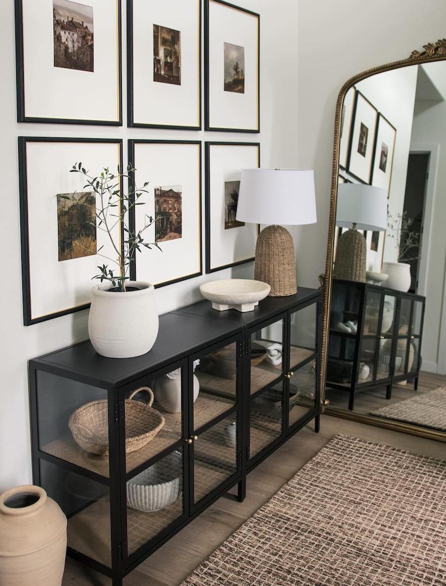 an entryway with black and white decor and a gallery wall