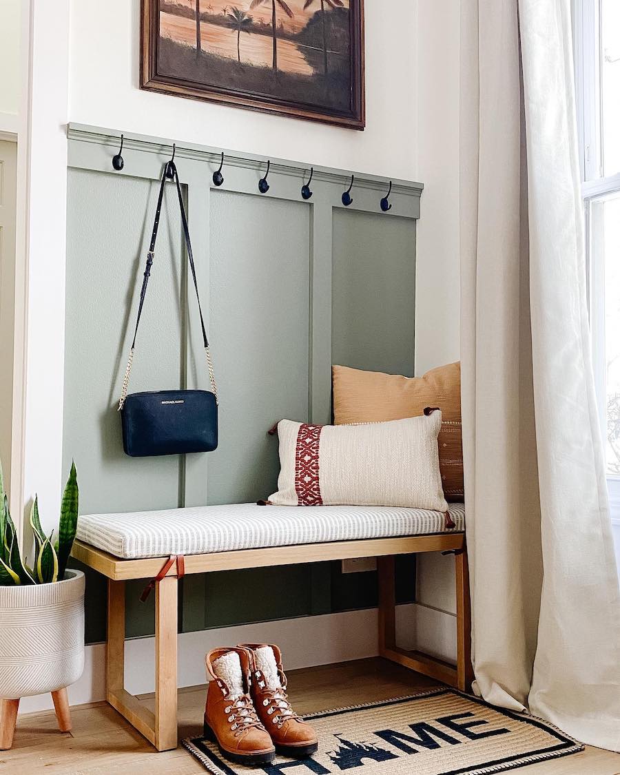 an entryway with a board and batten wall and a small bench