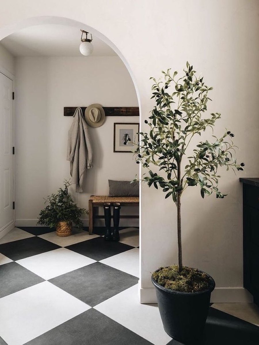 an entryway witch checkered tiles and a woven bench