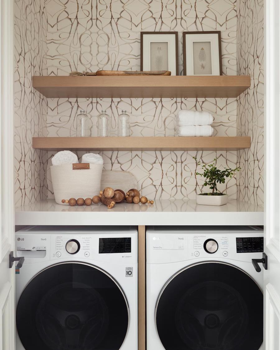 a small laundry room with open shelves and counters