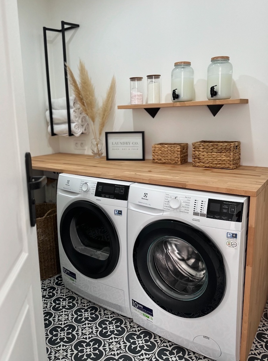 a small laundry room with wooden counters and added storage