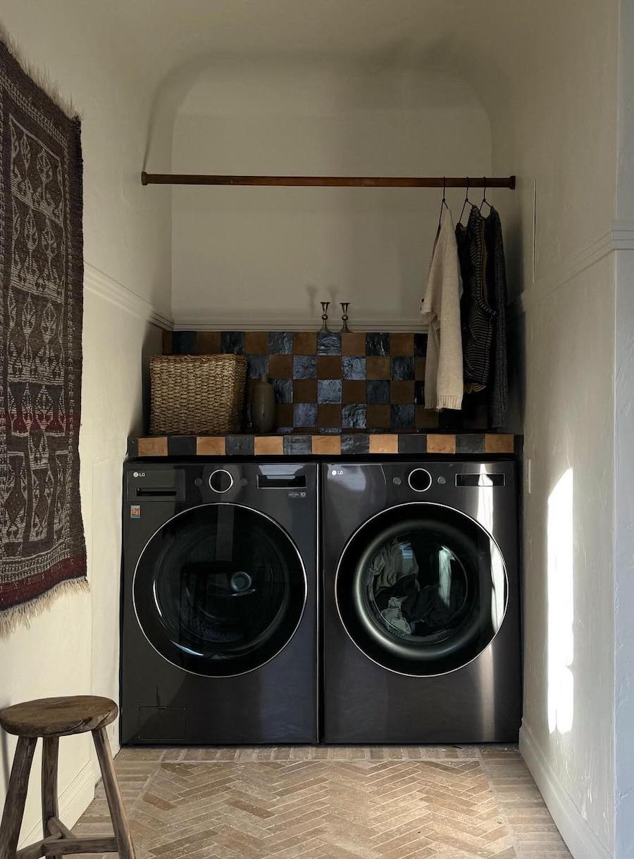 a small laundry room with a counter and hanging rod