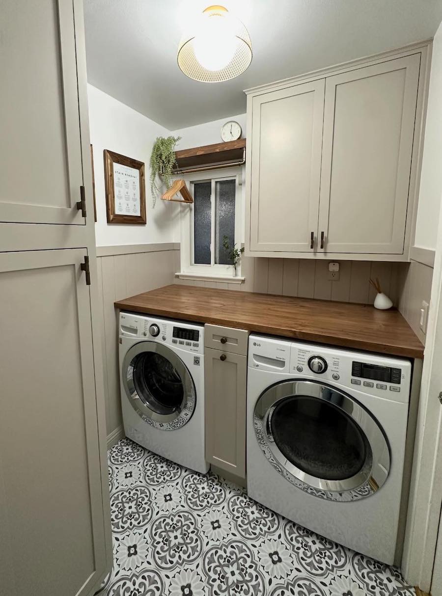 a small laundry room with counters and cabinets