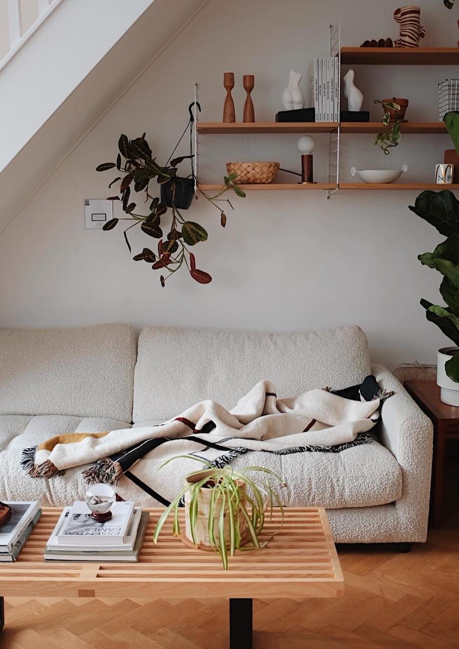 a living room featuring open shelving and a boucle couch