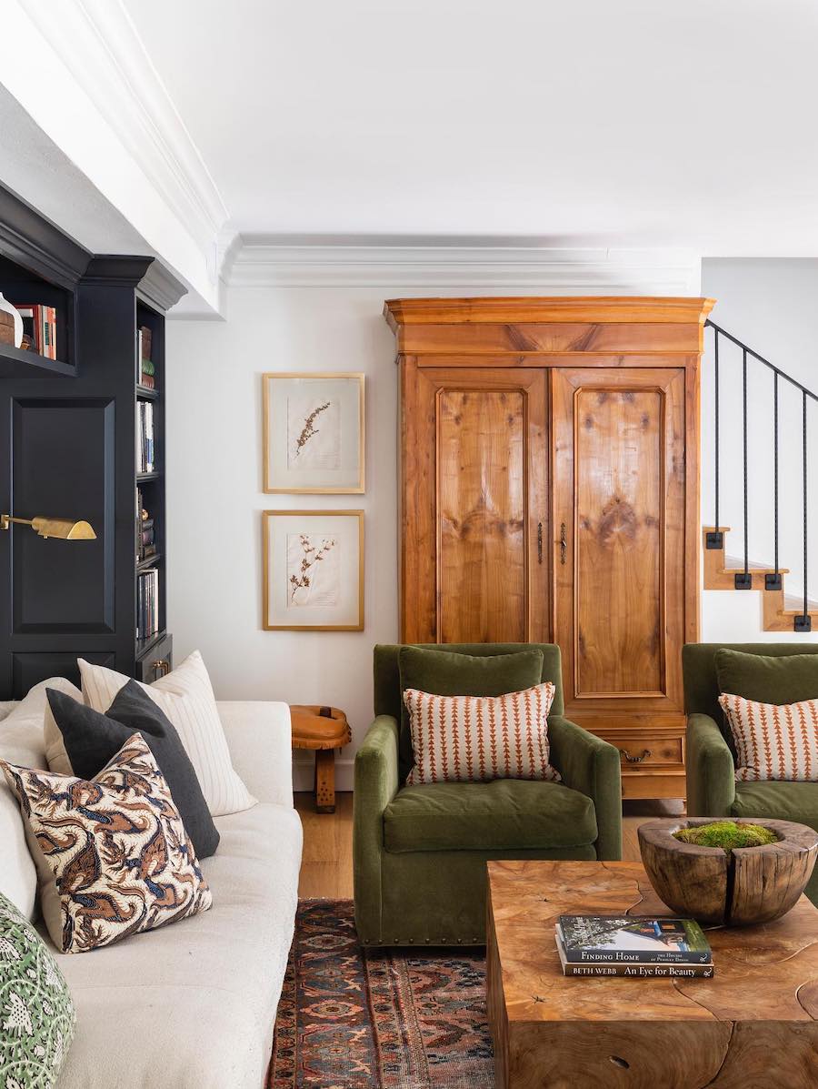 a living room featuring warm wood, black, and green furnishings