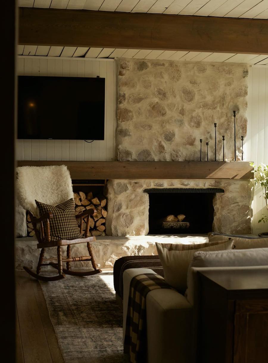 a living room featuring stone walls and rustic decor