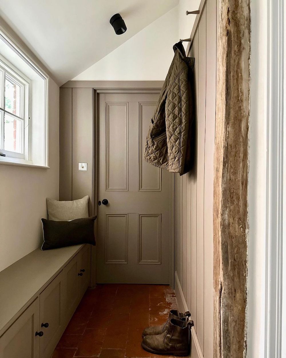 a mudroom with earthy decor and clothing storage